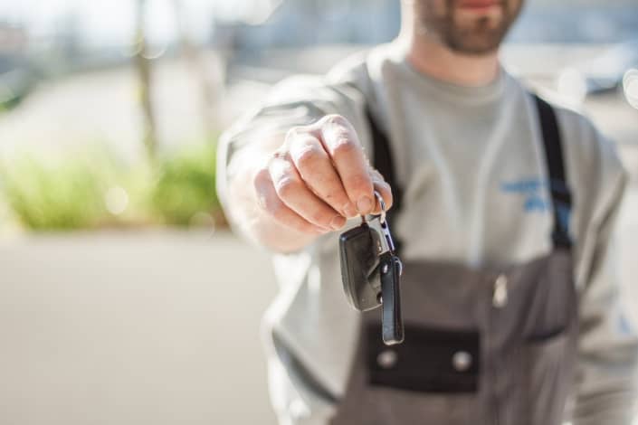 a person handing over a car key
